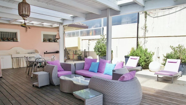 An outdoor patio with wicker furniture, a dining area, and a kitchen. - Villa Letizia (Chieti)