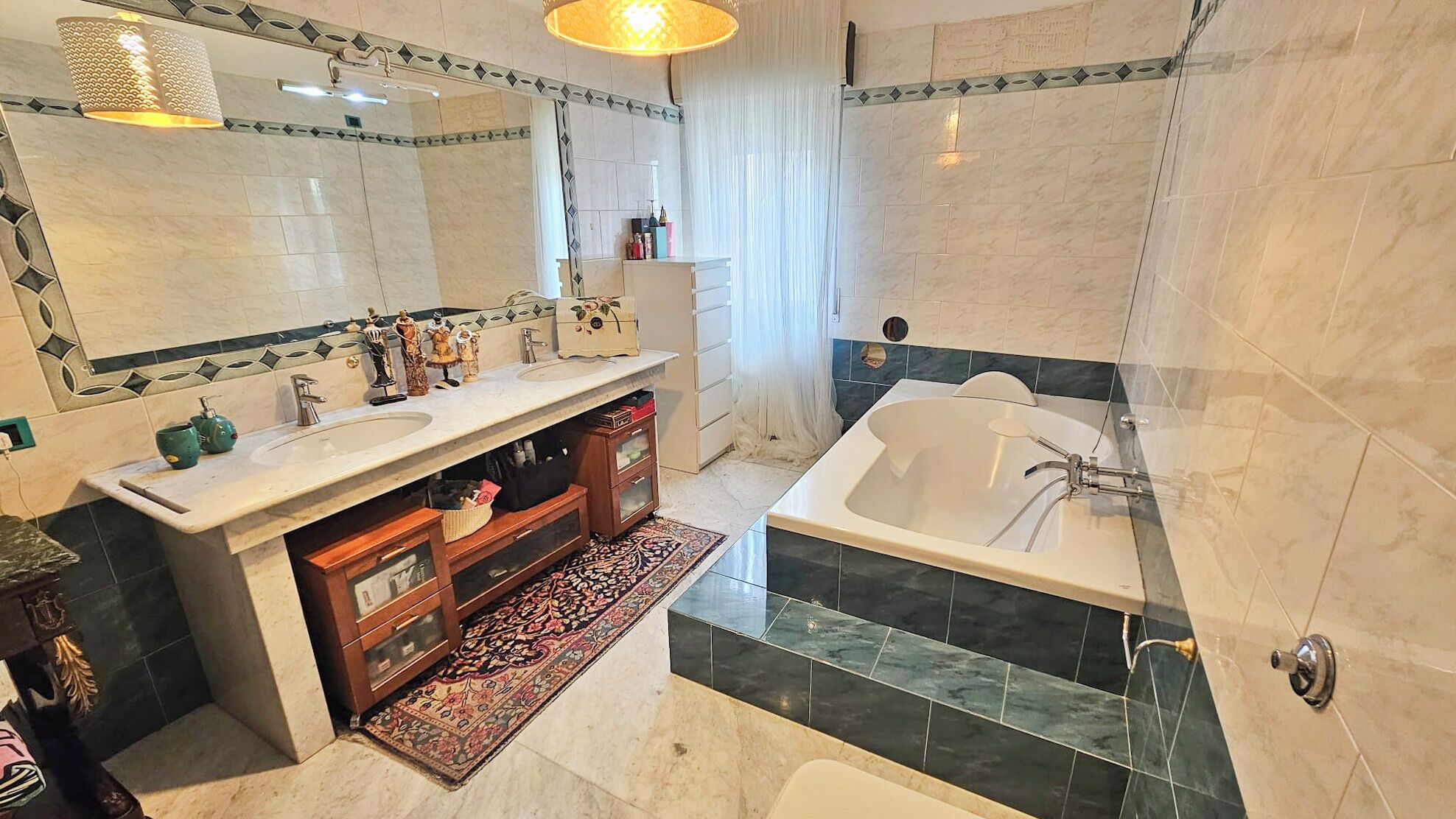 A modern bathroom with a double sink vanity, a bathtub, and a large mirror.