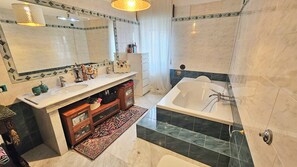 A modern bathroom with a double sink vanity, a bathtub, and a large mirror. - Villa Letizia (Chieti)