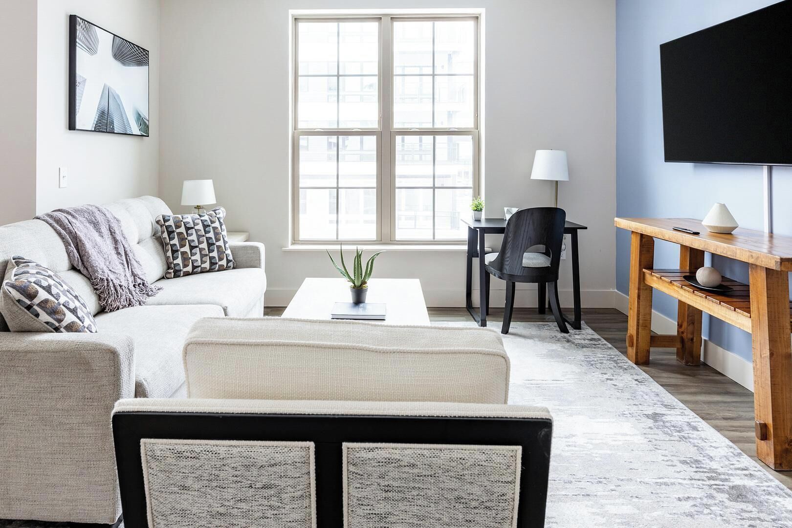 A modern living room with a sofa, coffee table, and a TV.
