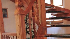 Un escalier en bois, agrémenté d’une rampe décorative et de marches recouvertes de moquette.