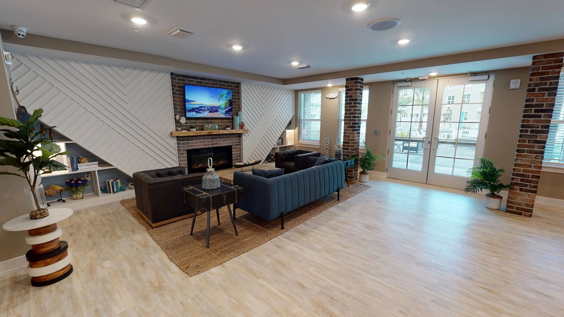 A spacious living room with a fireplace, a large TV mounted on the wall, and a comfortable seating area.