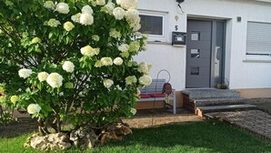A house with a number 5 mailbox, a grey door, and a white car parked in front. - Alb-Biosphere Holiday Apartment (Ingstetten)
