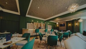 A modern hotel lobby with a bar area, seating arrangements, and a television screen. - Cairndale Hotel & Spa (Dumfries)