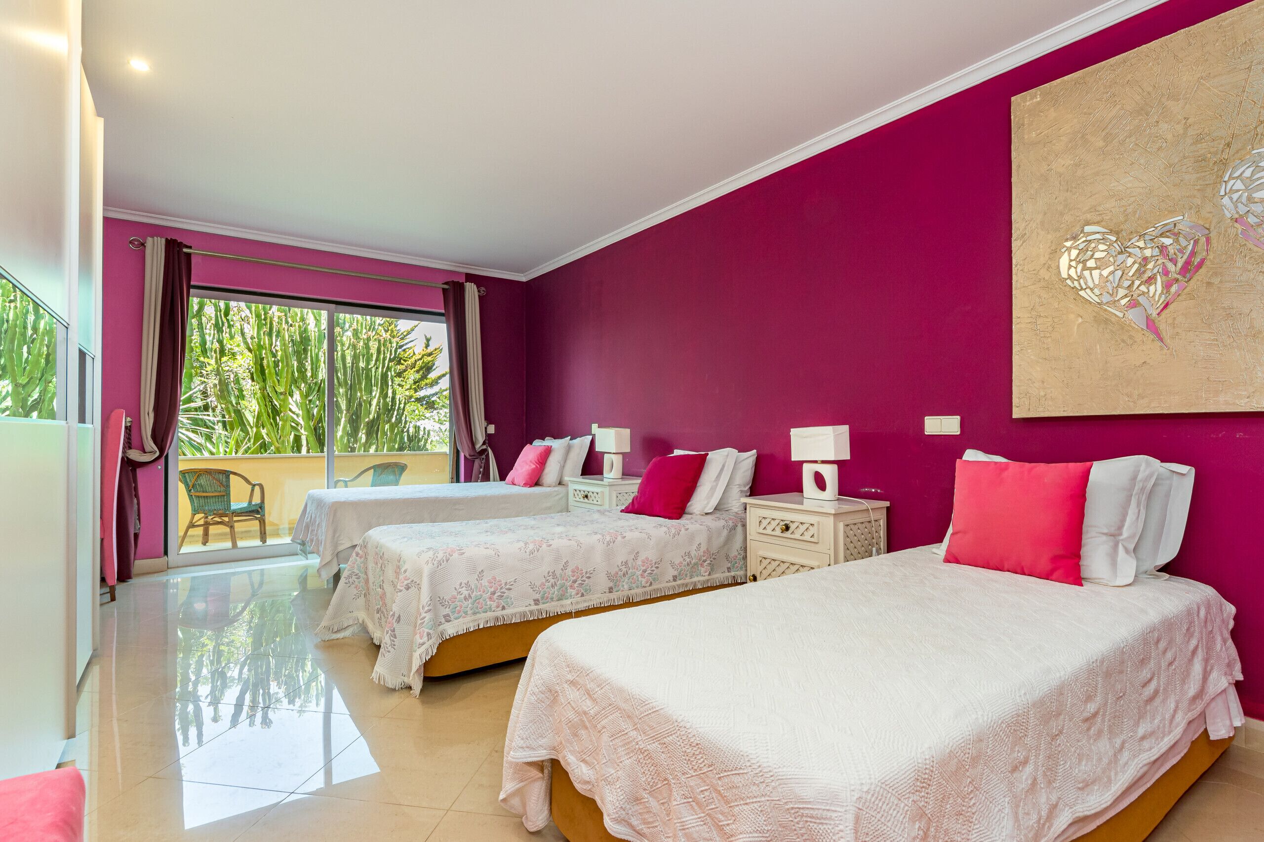 A room with two beds, a balcony, and a large window.