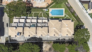 An aerial view of a hotel with a rooftop pool, a landscaped garden, and a parking area. - Villa Moises  - an excellent property 500 mts from the famous Falésia beach (Albufeira)