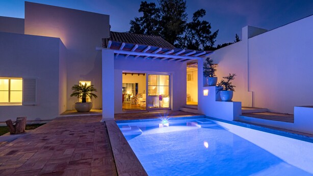 A modern house with a swimming pool, a patio, and a well-lit interior. - Villa AL Fresco, a cosy villa with fabulous exterior areas & private pool (Guia)