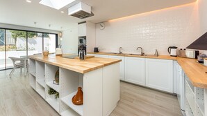 A modern kitchen with a wooden island, white cabinets, and a skylight. - Villa AL Fresco, a cosy villa with fabulous exterior areas & private pool (Guia)