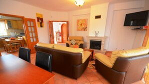 Ein Wohnzimmer mit Kamin, Sofa und Essbereich.