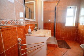 A bathroom with a sink, mirror, shower, and a window. - Villa Casa das Amendoeiras, a lovely 4 bedroom villa with private pool (Alcantarilha)