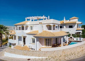 A large, white, two-story house with a tiled roof, a swimming pool, and a stone pathway leading to the entrance. - Villa Cecilia has private pool, table tennis & is close to Albufeira (Albufeira)