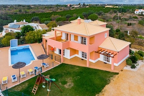 A large two-story house with a swimming pool, outdoor seating, and a playground. - Villa da Horta, a beautiful extensive villa in a peaceful location (Alcantarilha)