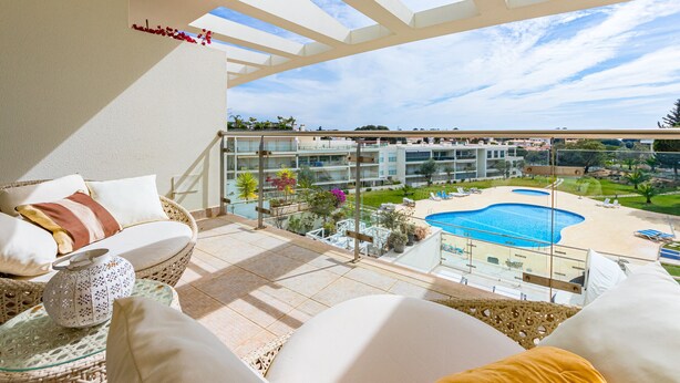 A balcony with a view of a swimming pool and a building complex. - Villa Seashell is a specious 3 bedroom townhouse on Monte da Balaia (Albufeira)