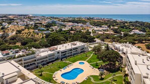 A resort with a large swimming pool surrounded by sun loungers and a view of the sea. - Villa Seashell is a specious 3 bedroom townhouse on Monte da Balaia (Albufeira)