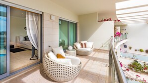 A balcony with wicker furniture, a sliding glass door, and a view of the interior. - Villa Seashell is a specious 3 bedroom townhouse on Monte da Balaia (Albufeira)