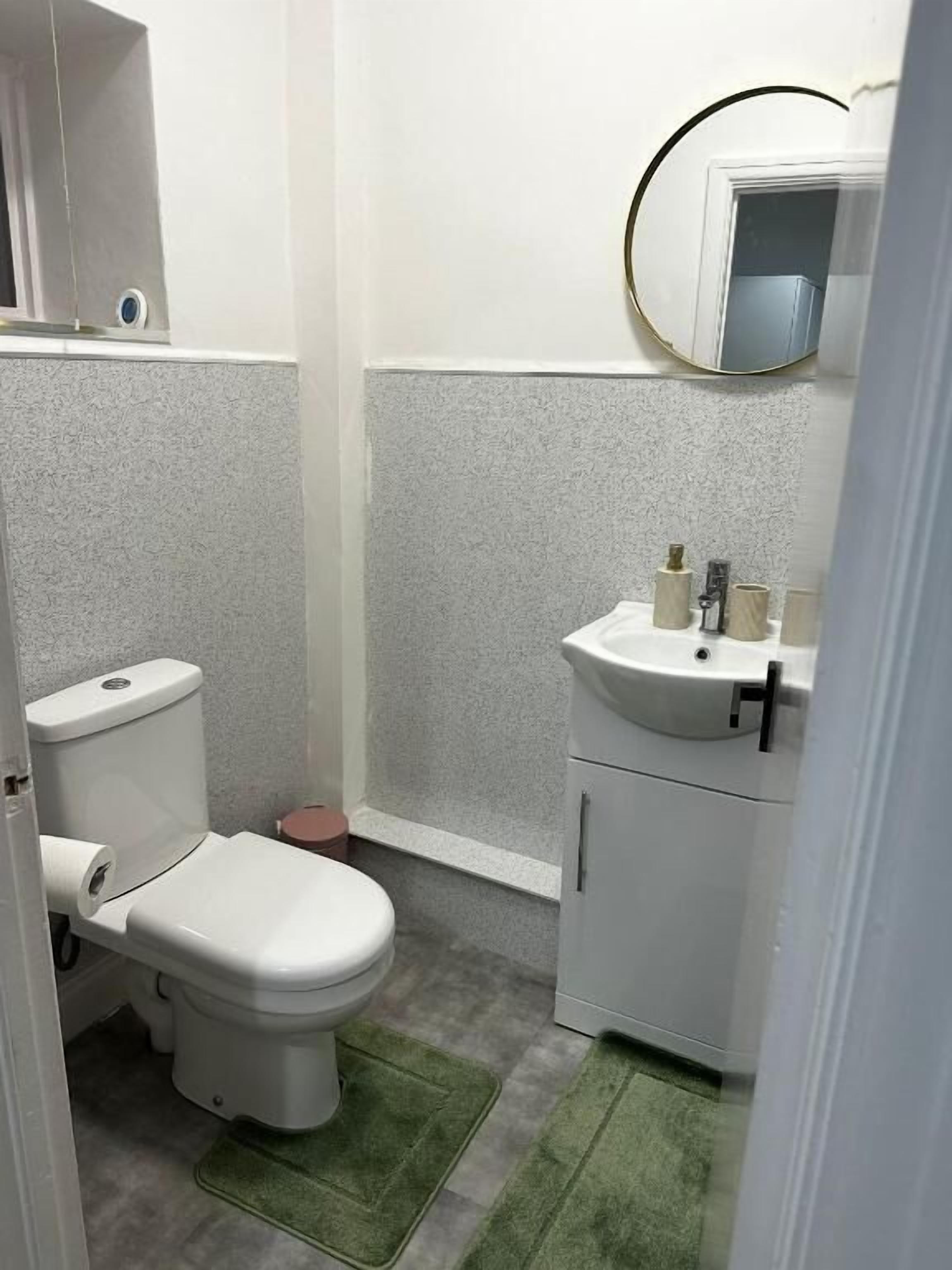 Une petite salle de bain avec des toilettes, un lavabo et un miroir.