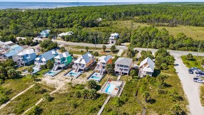A coastal residential area with multiple houses, a swimming pool, and a beach. - The Turtle's Nest (Port St. Joe)
