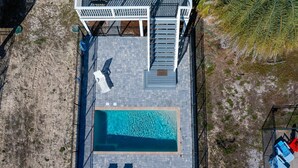 An aerial view of a rectangular swimming pool with two lounge chairs and a small deck area. - The Turtle's Nest (Port St. Joe)