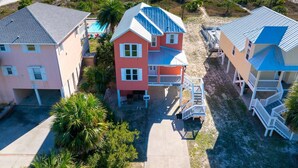A coastal property with a two-story house featuring a blue roof, a pink house, and a beige house with a blue roof. - The Turtle's Nest (Port St. Joe)