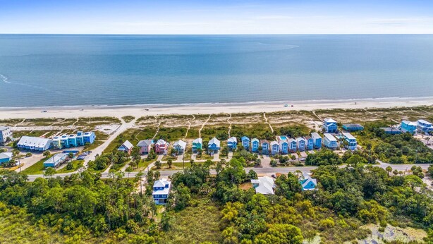 Een kustresort met strandvilla's, een jachthaven en een strand.