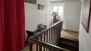A staircase with a wooden handrail leading to a landing. A red curtain is partially visible on the left. - Au pré du Puy (Chanverrie)
