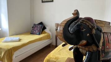 A room with a bed, a small table, and a decorative elephant sculpture.
