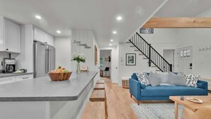 A modern kitchen with white cabinets, a built-in island, and a coffee machine.