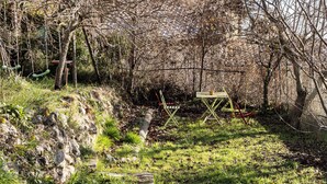 A garden with a stone pathway, a wooden bench, and a metal fence. - Between sea and mountains, pets welcome, hiking, walks from the house (Revest-les-Roches)