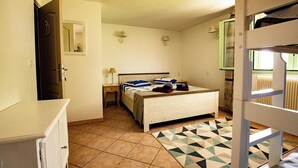 A bedroom with a bed, bedside tables, a dresser, a mirror, and a geometric-patterned rug. - Between sea and mountains, pets welcome, hiking, walks from the house (Revest-les-Roches)