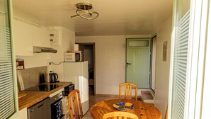A compact kitchen with a dining area, a built-in oven, and a microwave. - Between sea and mountains, pets welcome, hiking, walks from the house (Revest-les-Roches)