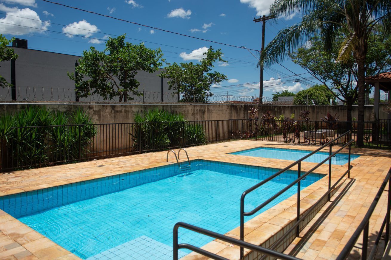 Piscina con bordes de azulejos y barandilla metálica.
