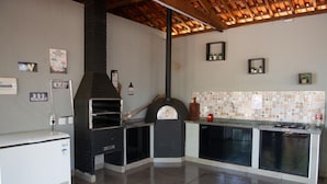A kitchen with a built-in oven, a refrigerator, and a tiled backsplash.