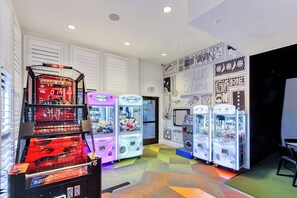 A room with arcade games, a basketball hoop, and a wall with various graphics and text. - Solara Resort Home Near Disney, Private Pool, Free Parking, Sleeps 12 (Kissimmee)