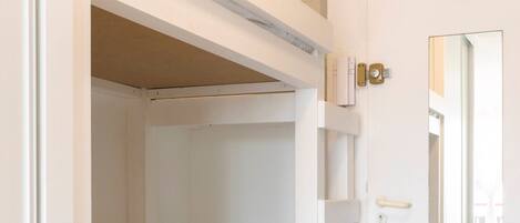 Habitación con literas, una puerta y un espejo.