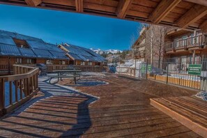 A wooden deck with a picnic table, a fenced area, and a mountain backdrop. - Ski-In/Out, Discount Tyra 1 bd/1 ba-Hot tubs! (Breckenridge)