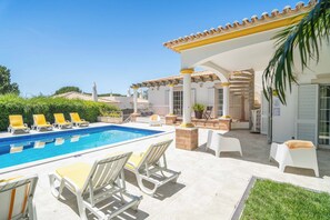 A pool area with lounge chairs, a covered patio, and a view of the surrounding landscape. - Zen Balaia - Four Bedroom Villa, Sleeps 8 (Olhos de Água)