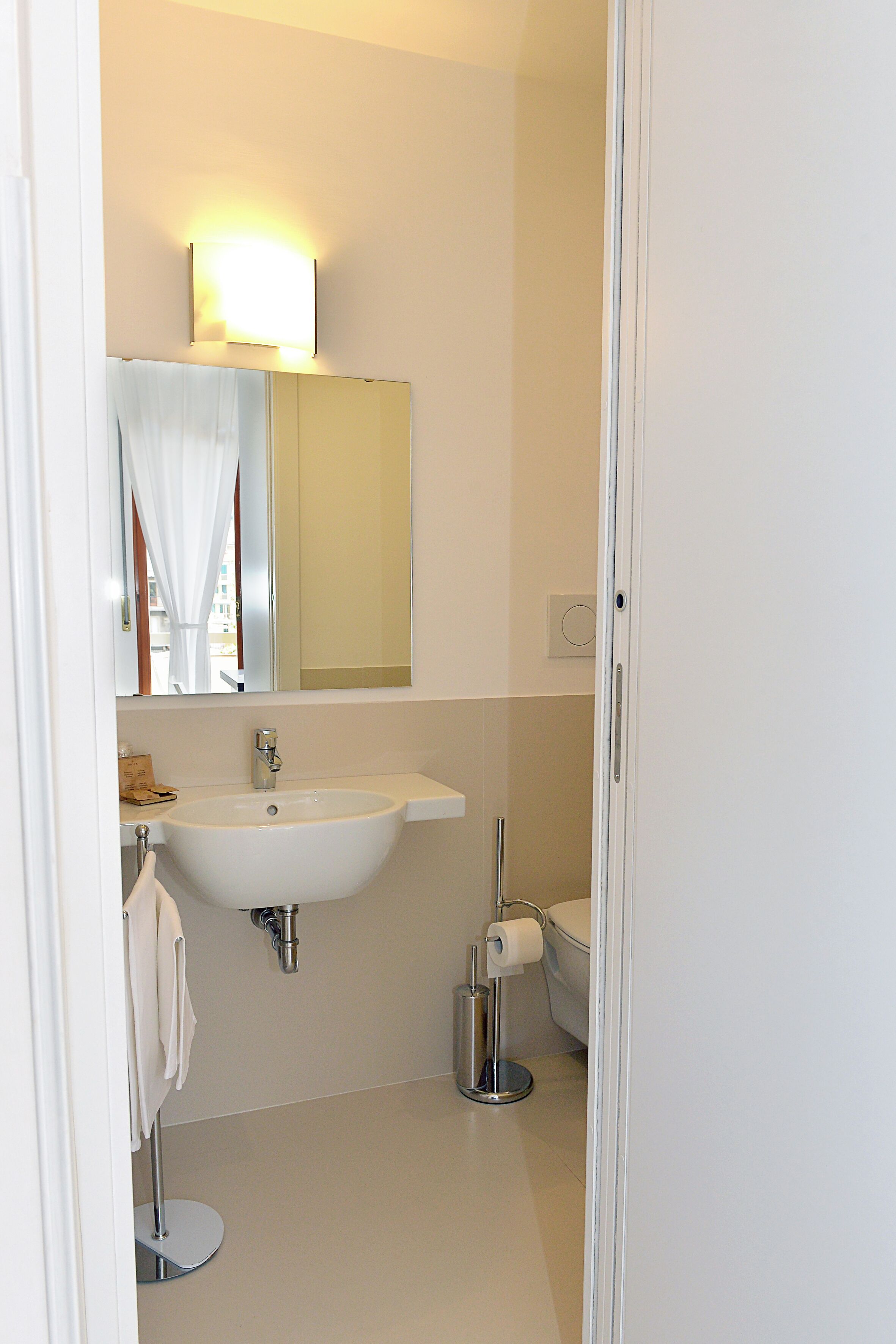 Ein Badezimmer mit Waschbecken, Spiegel und Toilette.