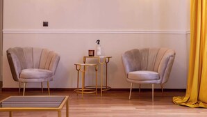 Una habitación con dos sillones, una mesita y una mesa de centro de vidrio.