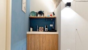Una cocina compacta con armarios de madera, una encimera y una pared azul.
