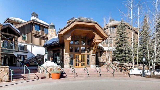 A lodge with a stone facade, wooden accents, and a prominent entrance with steps leading up to it. - Charming 2-bedroom 2- Bathroom Ski in/out apartment in Beaver Creek. (Beaver Creek)