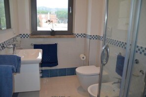 Une salle de bain avec une baignoire, des toilettes et une douche.