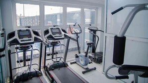 A gym with treadmills, an elliptical, and a stationary bike. - Alubarika Service Apartments (Lagos)