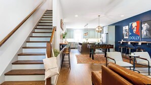 Un intérieur moderne comprenant un escalier, un coin repas et une cuisine.