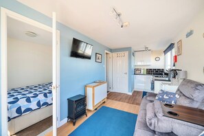 A compact living space with a kitchenette, a dining area, and a bedroom. - Bay View Sleeps 4, 2 Bedrooms Pets Garden Beach (Bridlington)