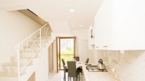 A modern kitchen with a dining area, a staircase, and a view of the outdoors. - Family Boutique Apartment - Borgo Pontone (8 pax) (Pontone)