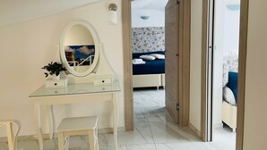 A bedroom with a bed, a bedside table, a mirror, and a dresser. - Family Boutique Apartment - Borgo Pontone (8 pax) (Pontone)