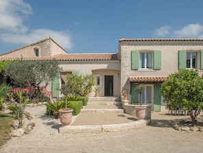 A two-story house with a tiled roof, green shutters, and a gravel driveway. - Appart Limonella - Appart avec terrasse et clim (Fontvieille)