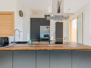 A modern kitchen with a wooden countertop, built-in appliances, and a view to the outside. - Bail mobilité - Appartement 2 ch - Nice centre (Nice)