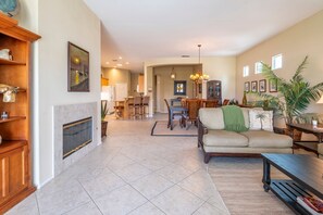 A spacious living room with a fireplace, dining area, and a cozy seating area with a sofa and coffee table.
