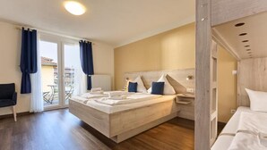 A modern bedroom with a large bed, a bedside table, and a view of the outside balcony. - Hotel Apollon (Rust)